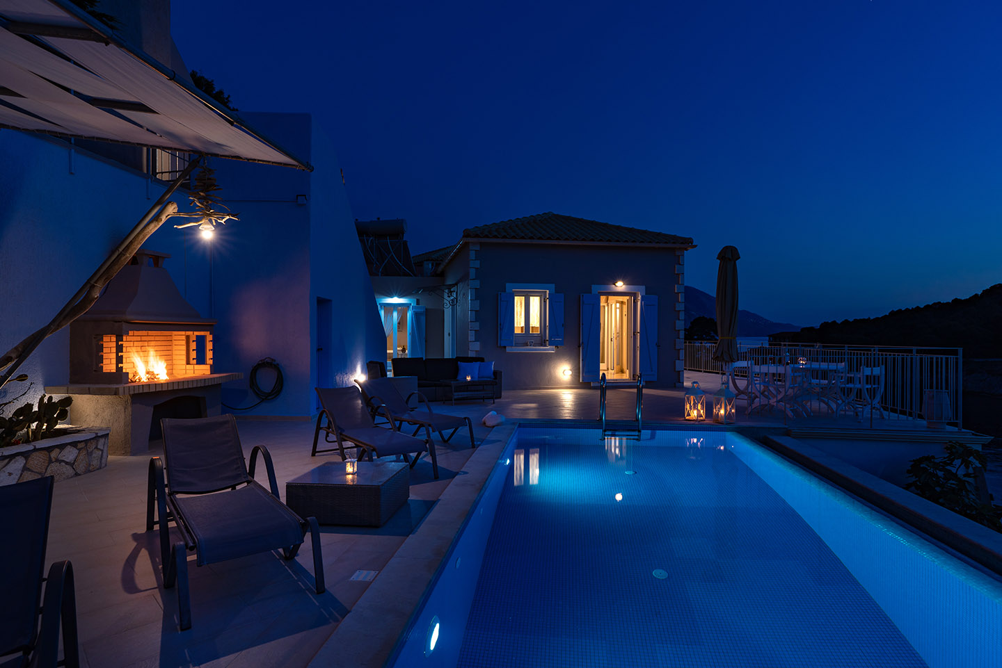 By the lighted infinity pool at night - Assos View villas
